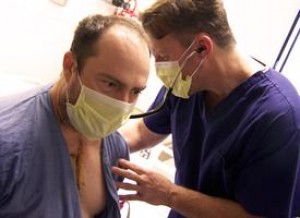 Heart transplant surgeon H. Todd Massey, M.D., listens to Daryl Williams' new heart beating in his chest.
