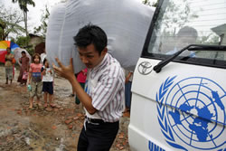 An aid worker of the United Nations High Commissioner for Refugees (UNHCR) distributes blankets to the survivors displaced by the cyclone "Nargis". Location: Yangon, Myanmar. 