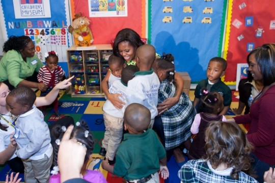 First Lady Michelle Obama shares a group hug with children at Royal Castle Child Development Center during her visit as part of her Let's Move! initiative in New Orleans, La., Nov. 1, 2011. Mrs. Obama read to the children and led them in exercises to highlight the importance of building healthy habits at a very young age. (Official White House Photo by Lawrence Jackson)